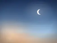A crescent moon in a bright blue daytime sky, illustrating the celestial view behind a Starrymaps daytime star map.